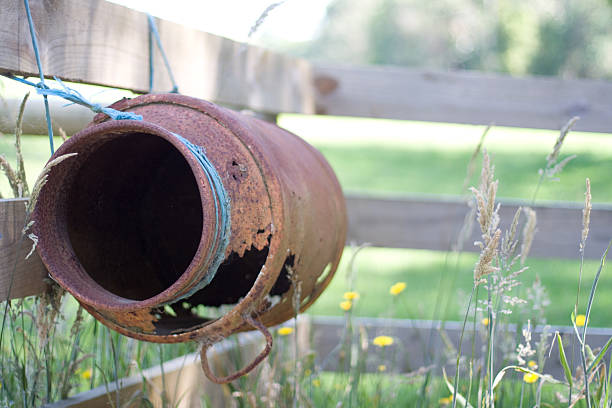 istock Rusty antique milk can tied to fence 153507478