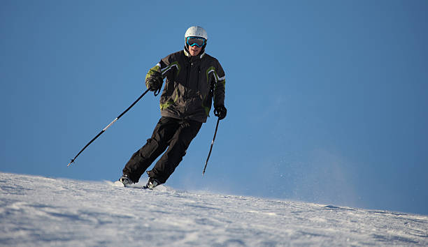 Teenage male skier on packed powder snow stock photo