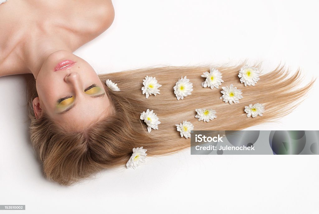 attractive young woman lying covered with flowers attractive young woman lying on white background covered with flowers Adult Stock Photo