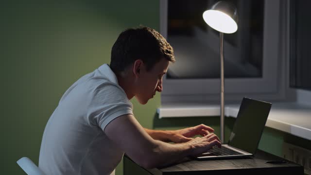 Male person with incorrect posture types on laptop keyboard