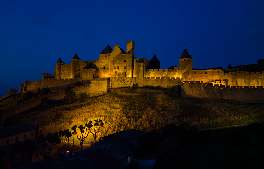 A nighttime view of the illuminated castle and medieval city of Carcassonne, Occitanie, France.