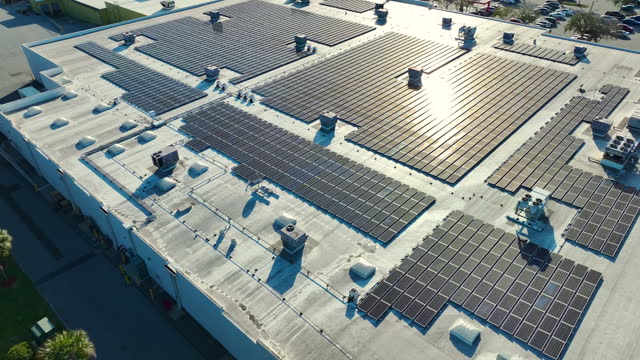 Electric photovoltaic solar panels installed on shopping mall building rooftop for production of green ecological electricity. Concept of producing sustainable energy