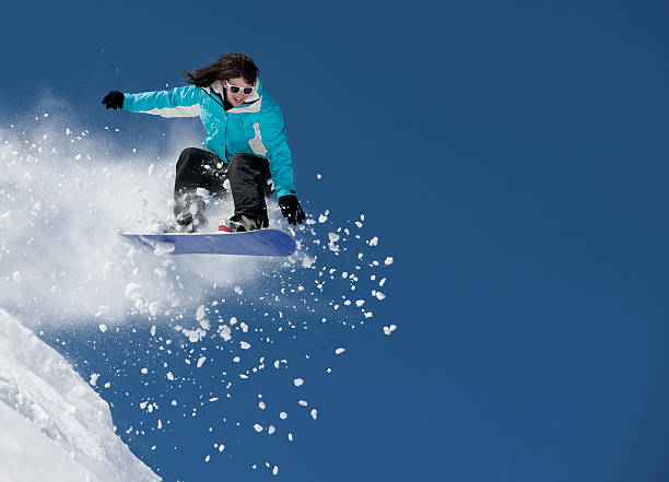 istock A female snowboarder jumping up into the air 153516705