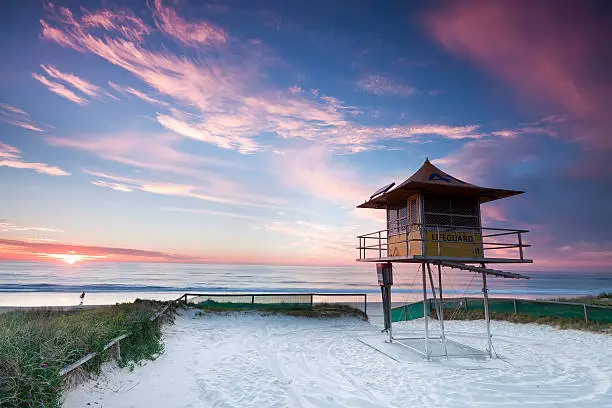 lifeguard hut on australian beach at sunrise with interesting clouds in background (gold coast, queensland, australia)
