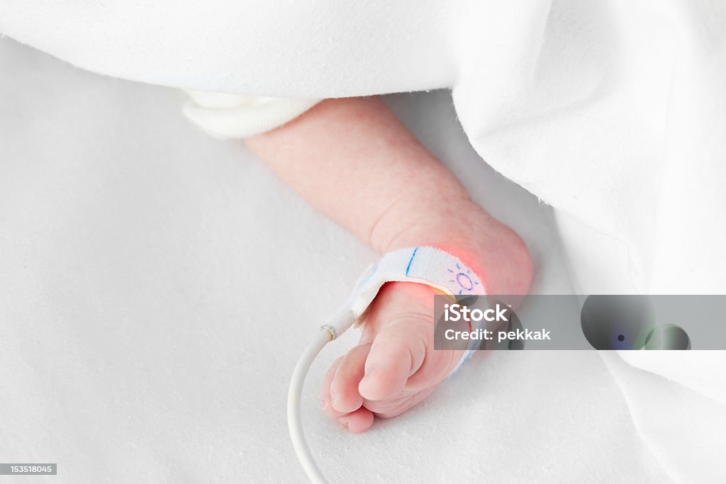 Piede di caucasica neonato con frequenza cardiaca al di fuori della copertura 2 - Foto stock royalty-free di Bebé