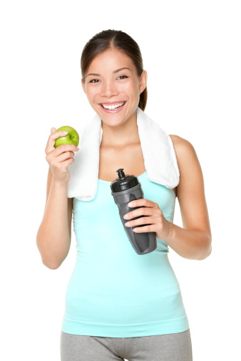 Healthy lifestyle - fitness woman eating apple smiling happy looking at camera. Pretty mixed race Caucasian Asian woman isolated on white background. Click for more