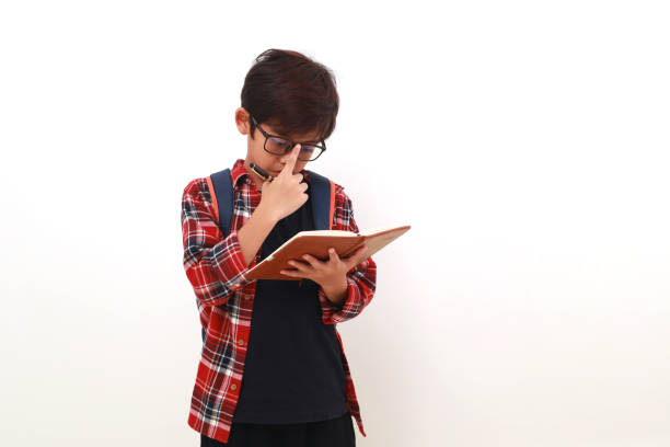 istock Thoughtful asian student holding a book while thinking something. Isolated on white 1535244383
