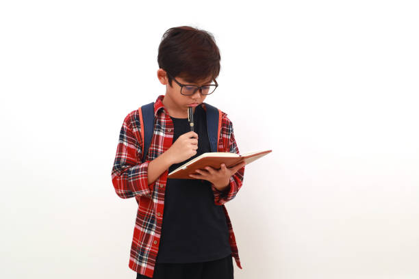 istock Thoughtful asian student holding a book while thinking something. Isolated on white 1535245397