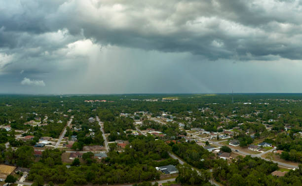 istock Dark stormy clouds forming on gloomy sky before heavy rainfall over suburban town area 1535250090