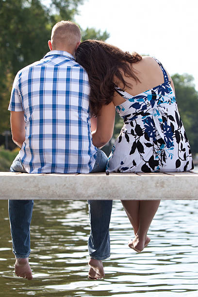 istock Young happy couple sitting on lake pier 153525353