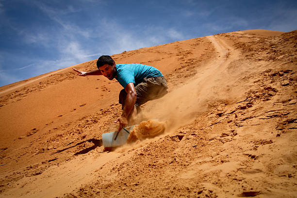 Sandboarding Man boarding on sand dune in Mui Ne - Viet - Nam mui ne bay photos stock pictures, royalty-free photos & images