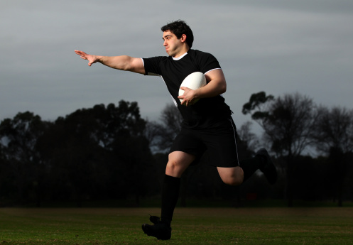 A Rugby Player Runs with the Ball