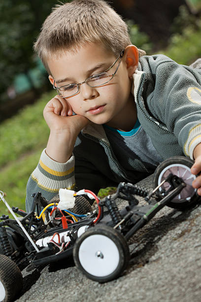 istock happy boy looking in radio controlled car 153528203