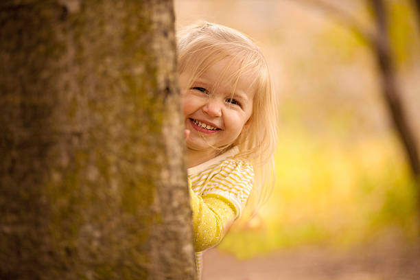 istock Little Girl Hiding Behind a Tree. 153529428