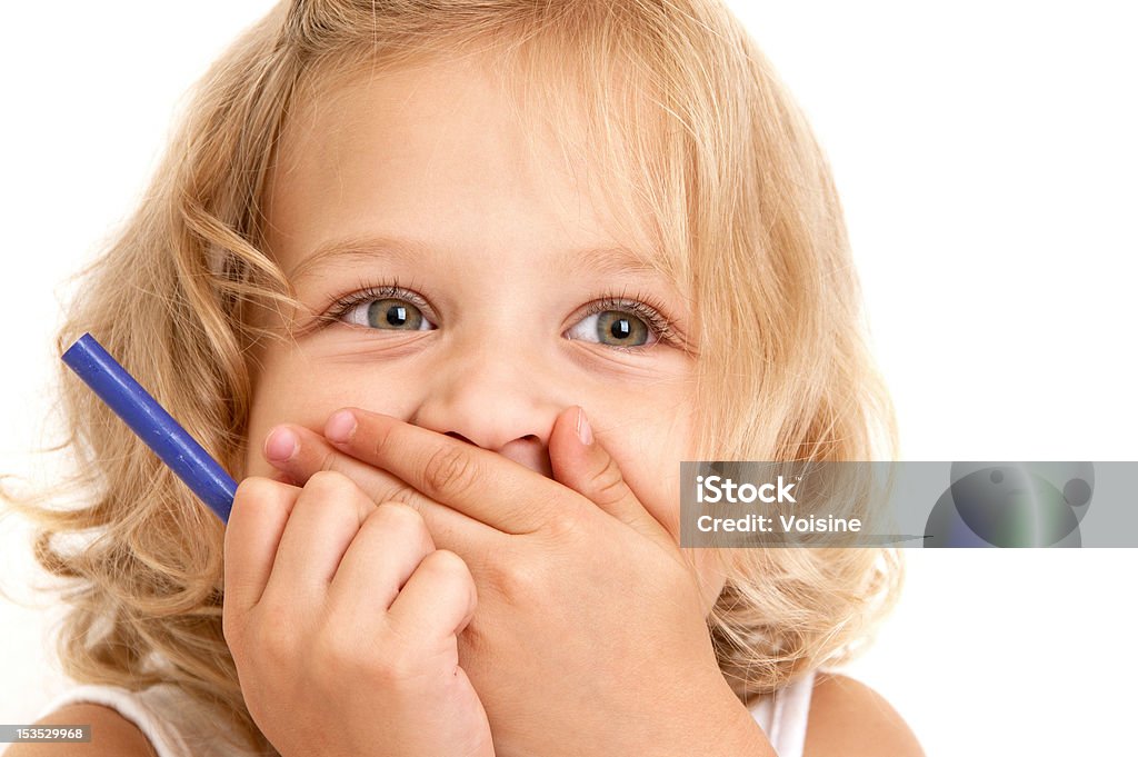 Laughing little girl Laughing little girl covers her mouth with her hands and holding a pencil in her hand close-up on  white background Beautiful People Stock Photo