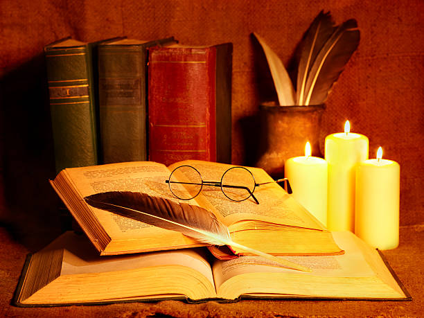istock A stack of old books next to a candle 153531104
