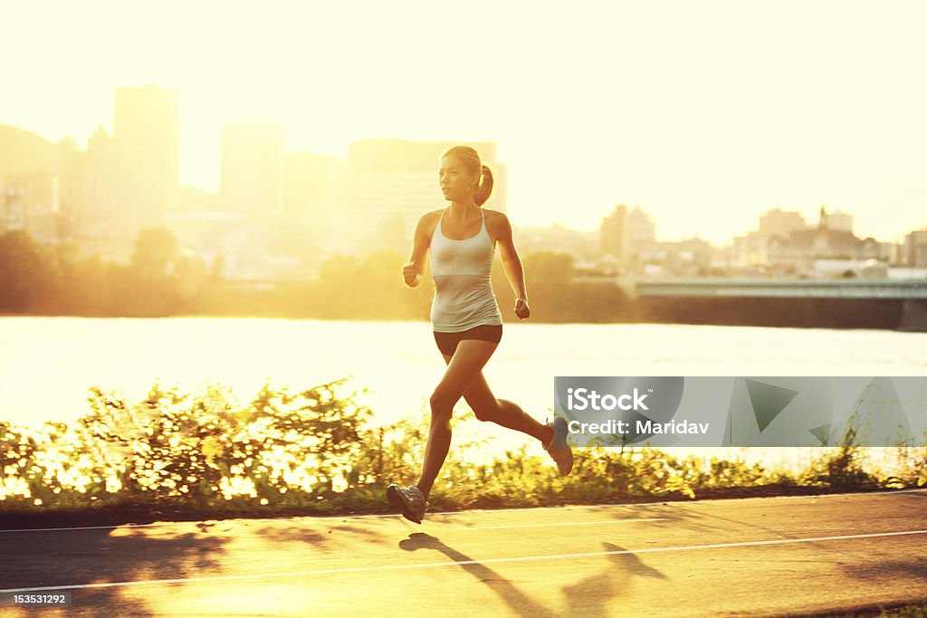 Female runner running at sunset female runner running at sunset in city park. Healthy fitness xwoman jogging outdoors. Montreal skyline in background.Running in city park. Click for more: Running Stock Photo