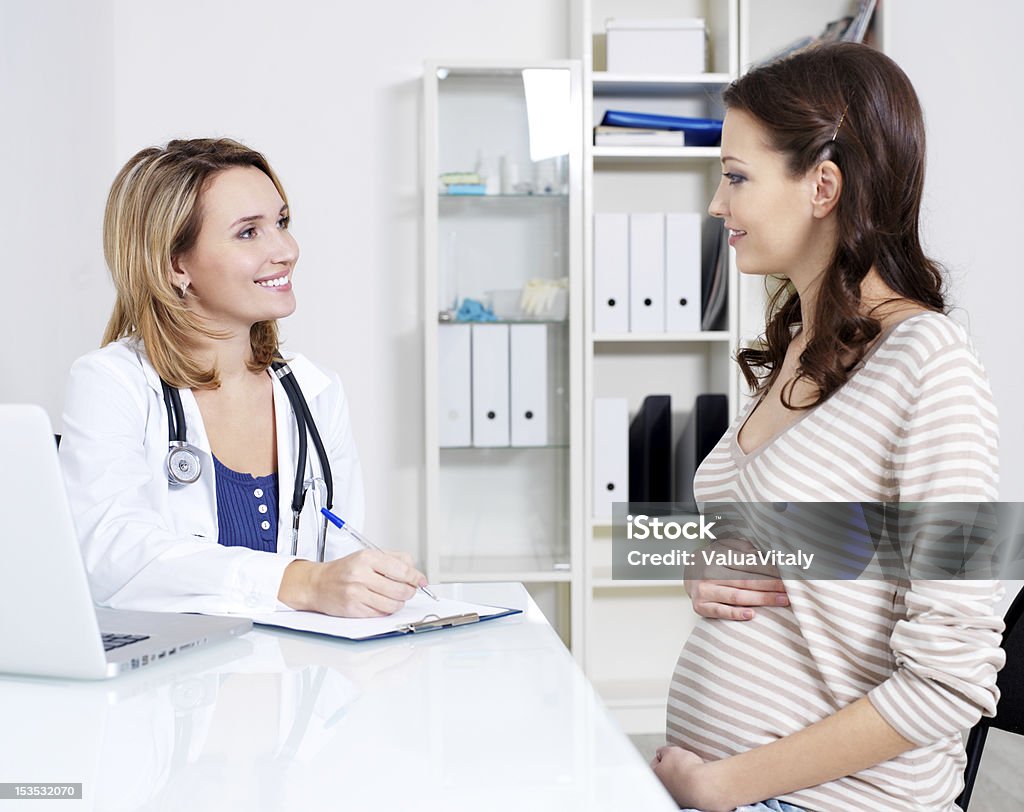 Consultation of pregnancy Consultation of young pregnant woman with her doctor - indoors Pregnant Stock Photo