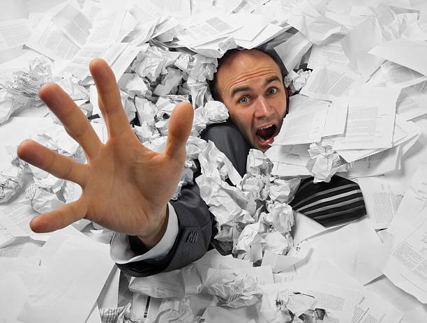 Businessman sinking in heap of documents Businessman sinking in heap of documents and asking for help buried stock pictures, royalty-free photos & images