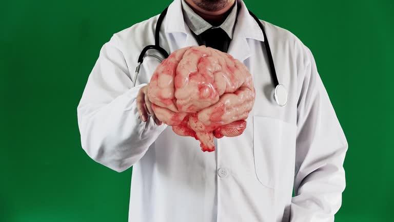 The doctor sits at the desk using virtual reality technology from the phone to examine the patient's brain by reviewing the hologram images.