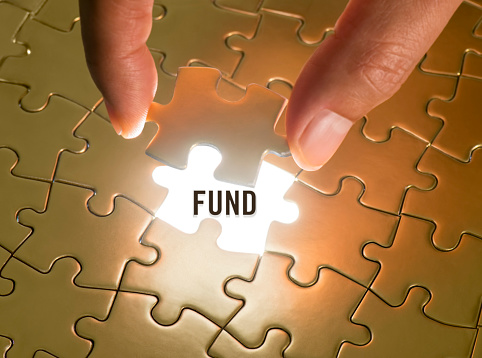Hand holding a puzzle piece with “Fund” text underneath