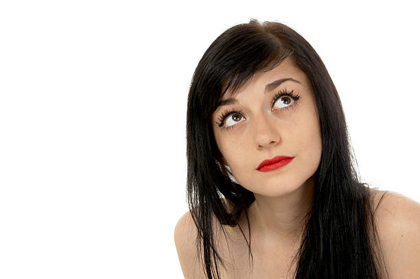 Beautiful brunette girl   looking up thoughtfully on white background close-up