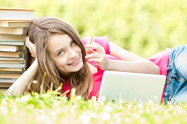 istock happy student girl lying on grass with laptop computer 153534977