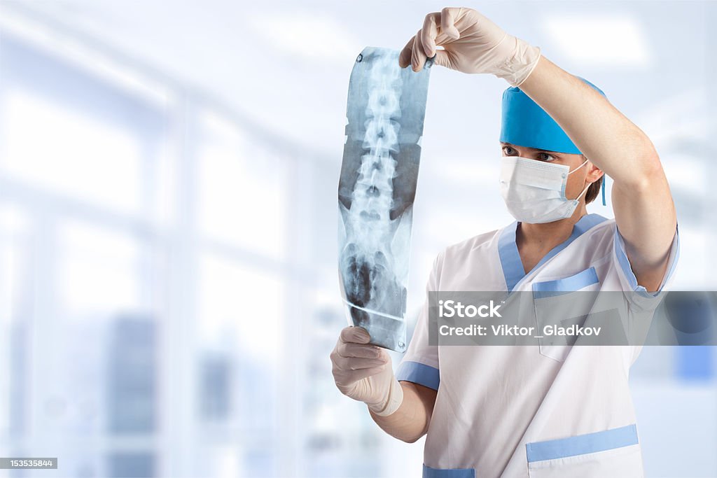 medical doctor looking at x-ray picture of spine medical doctor looking at x-ray picture of spine in hospital with copy space Adult Stock Photo