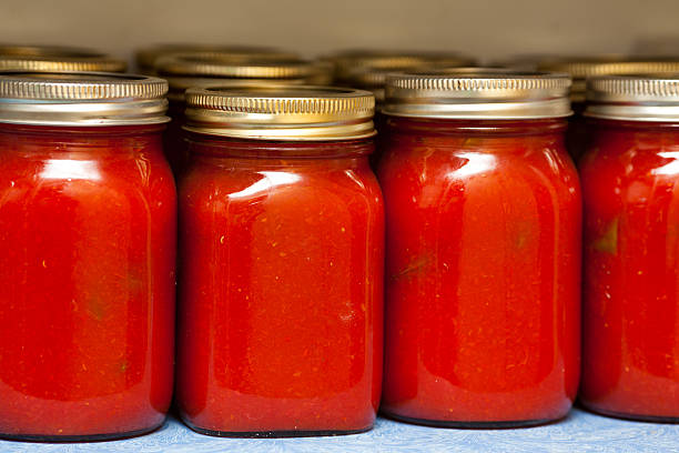 Jars of Tomato Sauce Preserved jars of tomato sauce in a pantry. marinara stock pictures, royalty-free photos & images