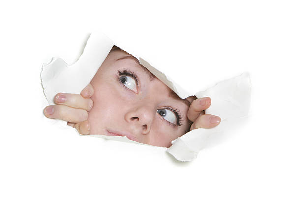 istock woman peeping through hole in paper 153540199