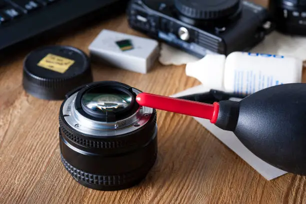 Camera and lens care. Camera cleaning kits and camera gears on photographer's desktop.
