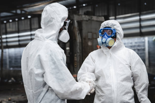 istock Scientist workers wear protective suit shack hand with team when working success. Protecting Against Hazards and Contamination. 1535460894