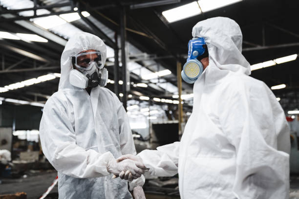 istock Scientist workers wear protective suit shack hand with team when working success. Protecting Against Hazards and Contamination. 1535463485
