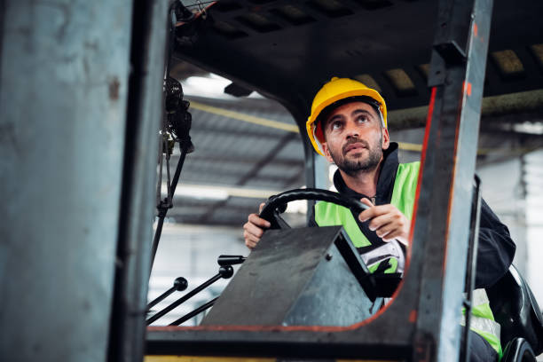 istock Industrial worker driving a forklift in the factory. Efficient Logistics Management and Teamwork in Manufacturing and Distribution Industry. 1535471638