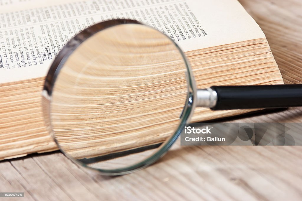 old book and magnifying glass old open book and magnifying glass Book Stock Photo