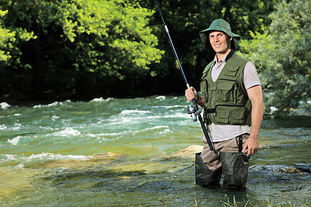 A young fisherman posing with fishing pole in his hand on a river Treska, Macedonia