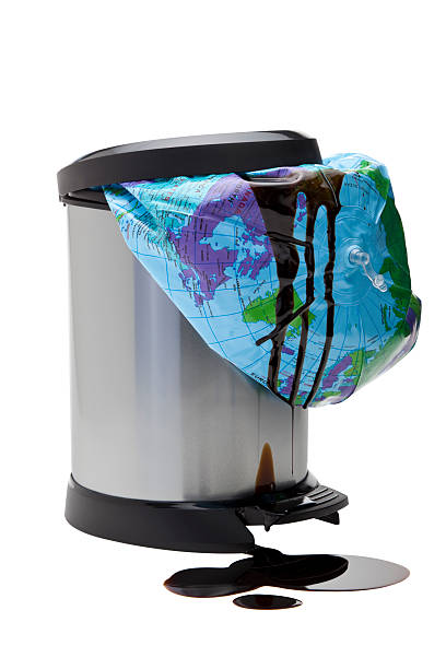 Renewable energy concept Oil leaking from a discarded polluted planet thrown away into a bin - image isolated. A concept to find an alternative energy source to reduce global warming. pedal bin stock pictures, royalty-free photos & images