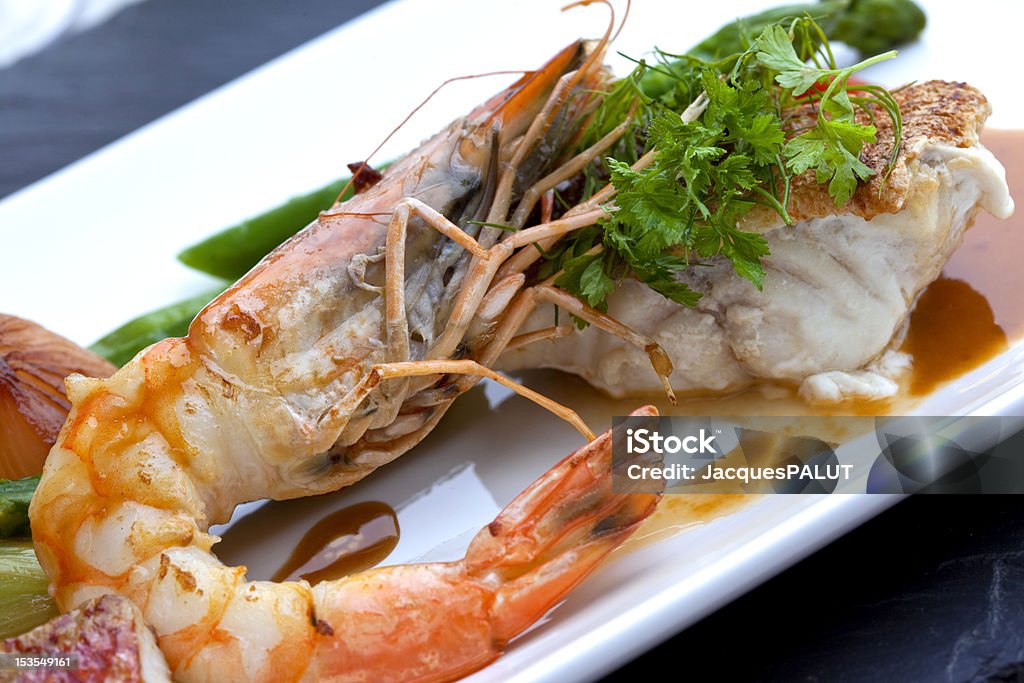 Gastronomy Prawns and codfish with sauce on a plate Au Jus Stock Photo