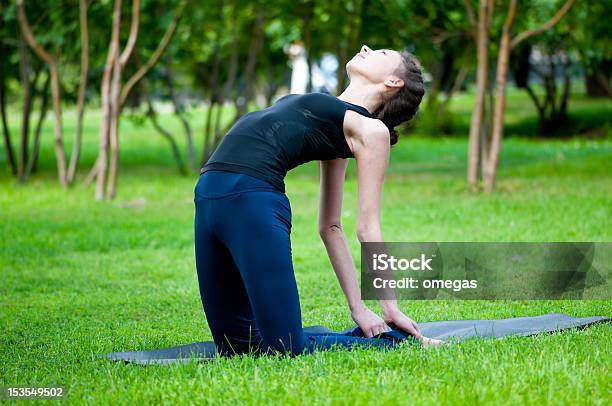 Foto de Mulher Fazendo Exercícios De Alongamento A Ioga e mais fotos de stock de Adolescente - Adolescente, Adolescentes Meninas, Adulto