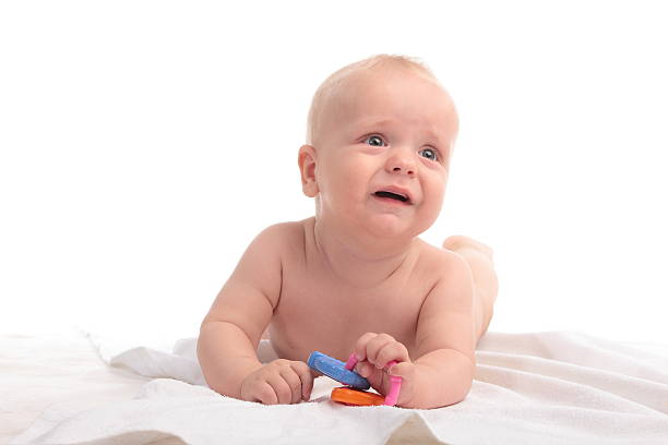 crying newborn baby boy with toy stock photo