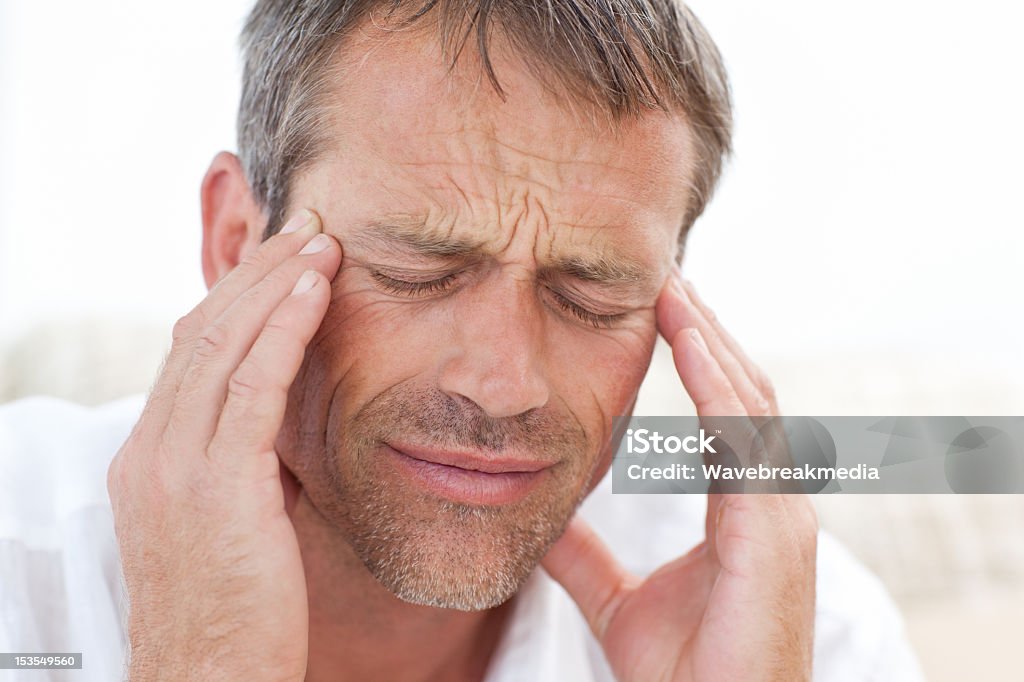 Man having a headache at home Adult Stock Photo