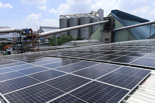 Solar PV on Factory Roof with Triangle Warehouse and Silo Background