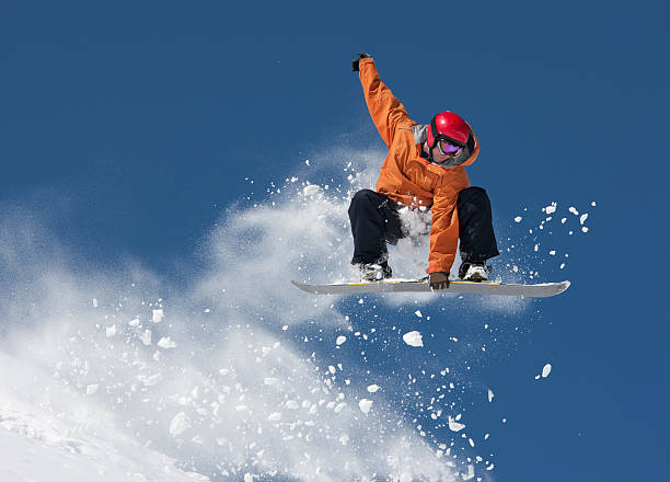 Snowboard Jump Young man suspended in mid-air making snowboard jump. boarding stock pictures, royalty-free photos & images