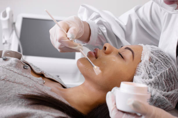 istock Cosmetologist applying cream essence essential vitamins into face to improve client skin. Beauty expert makes beauty treatment for patient. Health, skin care, aesthetic medicine concept. 1535516243