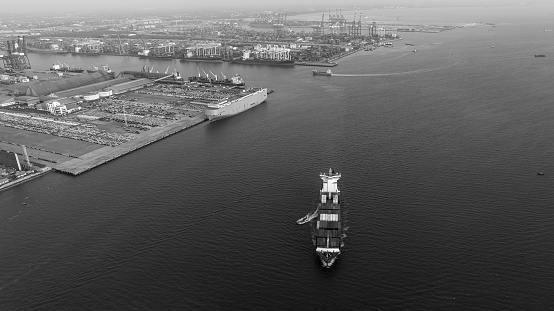 black and white photograph cargo container ship carrying in sea to import export goods and distributing products to dealer and consumers across asia pacific worldwide, global business and industry delivery service  by container ship Transport.