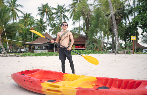 Young 30s asian wanderlust men ready for traveling and paddling kayak at krabi south of thailand asia