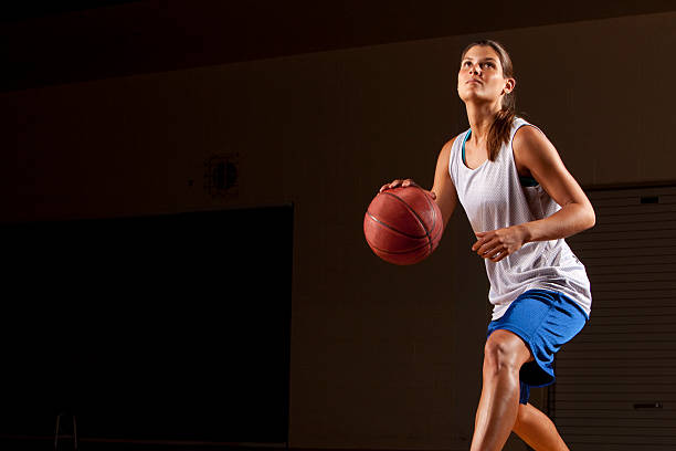 Mujer jugador de baloncesto en azul driblar de bola - foto de stock