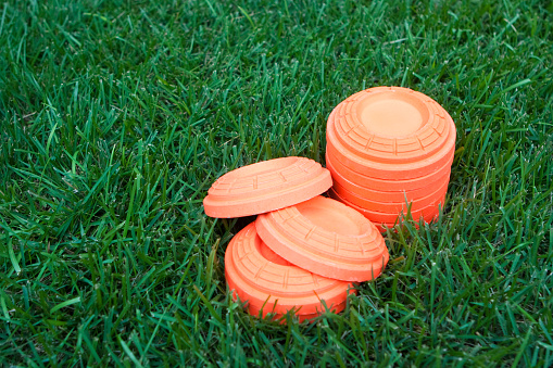 Unbroken clay targets set against green grass background with copy space on left.