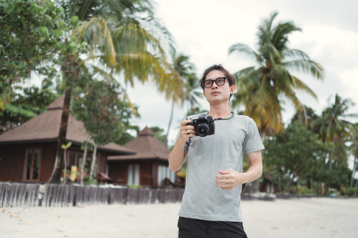 Asian influencer with dslr camera look for content social media relaxing at phuket ,Krabi province, Thailand