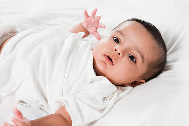 portrait of an adorable Indian baby girl. Adorable little baby girl laying in the bed. pakistan photos stock pictures, royalty-free photos & images